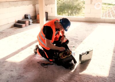 Stavbár s bezpečnostnou výbavou pri práci na stavenisku.