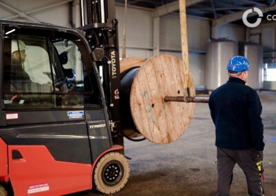 Priemyselná výrobná hala s pracovníkom a vysokozdvižným vozíkom.