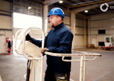 Ochranný technik s prilbou v priemyselnej hale, kontrola zariadení.